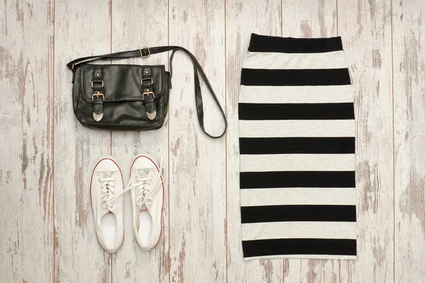 Gestreepte rok, zwarte tas en witte sneakers. Modieuze concept — Stockfoto