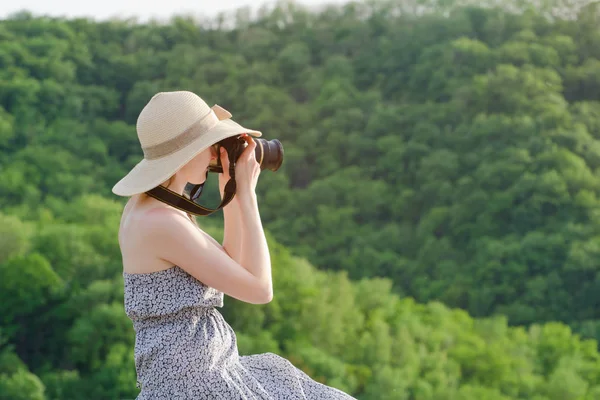Ragazza in cappello scatta foto sullo sfondo della foresta verde — Foto Stock