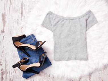 Gri üst, kot pantolon ve beyaz kürk, moda kavramı üzerinde siyah ayakkabı