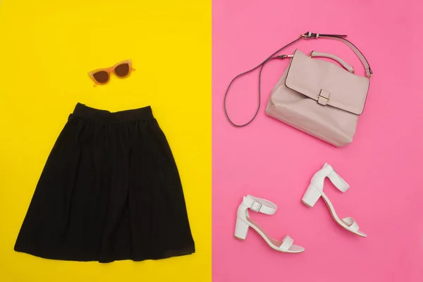 검정 치마, 핸드백, 흰색 신발 하 고 장밋빛 안경. 밝은 분홍색 노란 배경. 세련 된 개념 — 스톡 사진