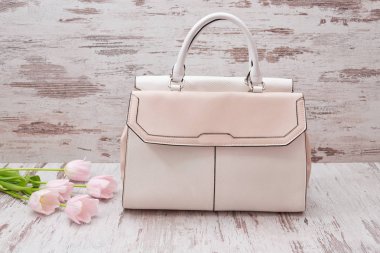 Ahşap arka plan, Pembe Lale üzerinde bej büyük çanta. Moda kavramı.
