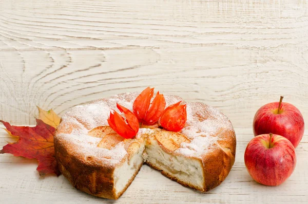 Elma elma tart ve olgun bir ışık ahşap arka plan üzerinde kesmek.