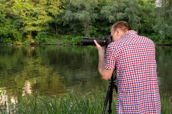 Il fotografo sta girando sulla riva del fiume, estate — Foto Stock