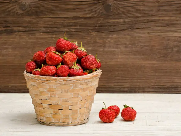 篮子的成熟草莓木制背景上 — 图库照片