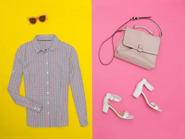 Gömlek küçük bir kafes, el çantası, beyaz ayakkabı ve gözlük. Parlak pembe-sarı arka plan