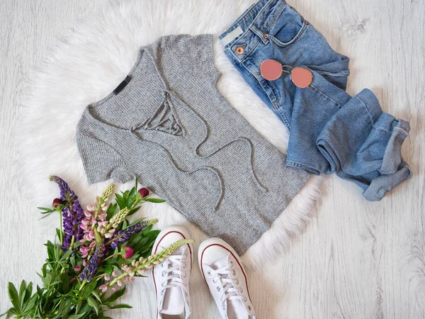 Modisches Konzept. Straßenstil. graues Hemd mit Schnürung, Jeans, Turnschuhen und Blumensträußen. — Stockfoto