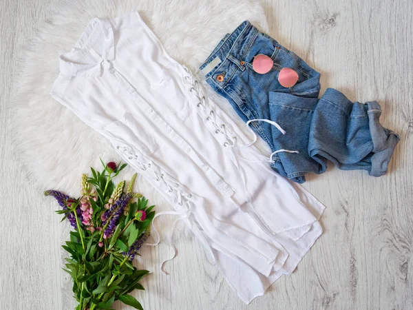 Concepto de moda. Blusa blanca con corbatas, jeans, gafas y ramos de flores . — Foto de Stock