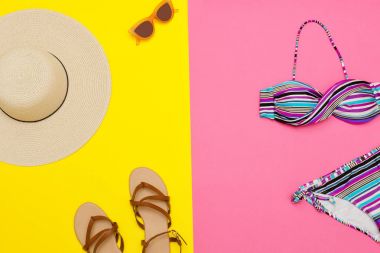 Beach kavramı. Kadın şapka, sandalet, Mayo, güneş gözlüğü. Sarı, pembe bir arka plan, üstten görünüm