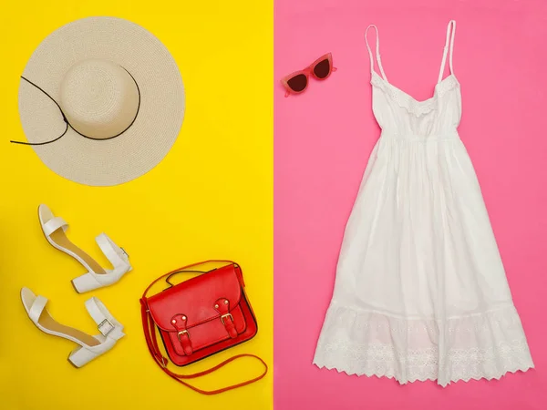 Vrouwelijke garderobe. Witte sundress, handtas, witte schoenen en een hoed. Lichte roze-gele achtergrond. Fashion concept — Stockfoto