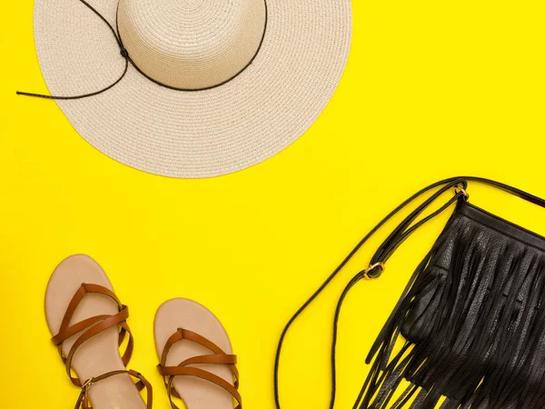 Moda kavramı. Bayanlar plaj şapka, çanta, sandalet. Sarı arka plan, üstten görünüm