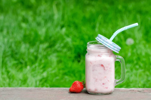 Yoğurt ve çilek yeşil çimen, metin için yer bir arka plan üzerine bir fincan