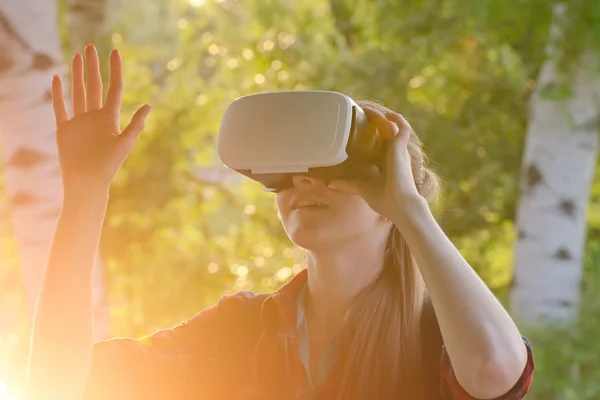 Mädchen im Helm der virtuellen Realität vor dem Hintergrund der Natur — Stockfoto