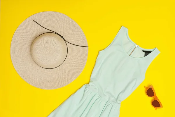Conceito elegante. Roupeiro de verão feminino. Vestido de menta, chapéu, óculos. Fundo amarelo, vista superior — Fotografia de Stock