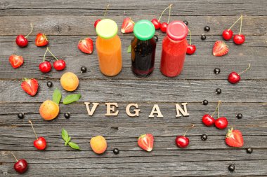 Üç şişe suyu, meyve ve yazıt vegan ahşap zemin, gıda kavramı ile