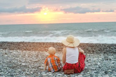 Şapkalı Kız gün batımını hayran. Yakın çekim. Arkadan görüntülemek