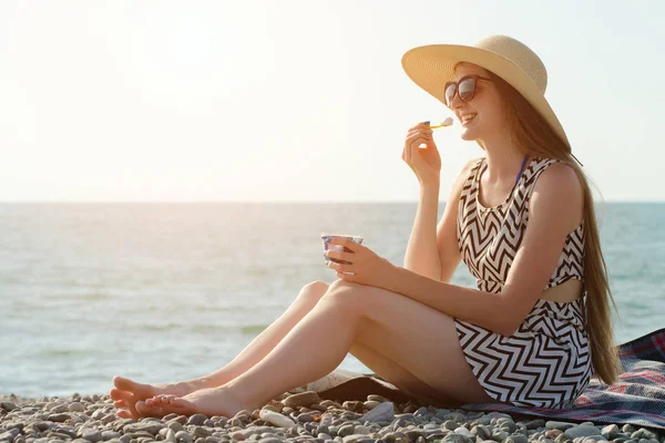 Plajda dondurma yeme şapkalı kız gülüyor. güneşli gün