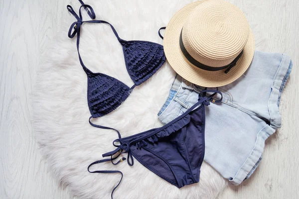 Strandkonzept. Damenhut, kurze Hosen, blauer Badeanzug. auf weißem Fell, Draufsicht — Stockfoto