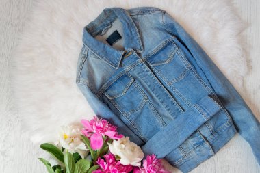 Kot ceket ve peonies bir buket. Moda kavramı, beyaz kürk arka planda