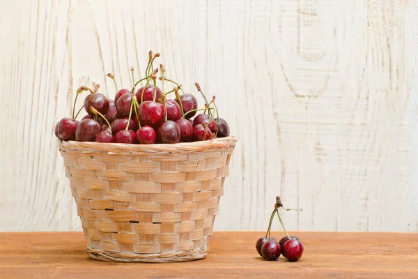 En kurv med kirsebær på et trebord. Tomt rom. – stockfoto