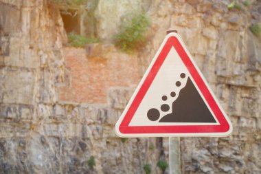 Yol işaret dikkat kaya düşmesi, bir kaya arka planı