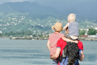 Babası iki oğlu ile sahilde hazır. Arkadan görüntülemek