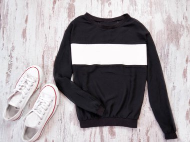 Siyah kazak ile beyaz şerit, beyaz spor ayakkabı. Moda kavramı