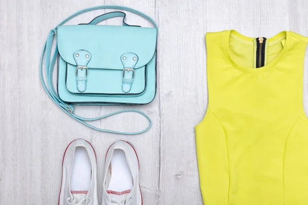 Ljus grön blus, vita sneakers och handväska. Fashionabla koncept. Trä bakgrund. — Stockfoto