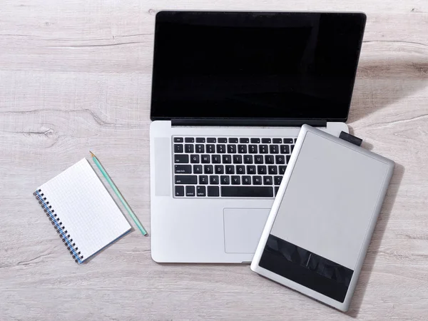 Pensil masa lambası, üstten görünüm üzerinde laptop, grafik tablet ve not defteri açın