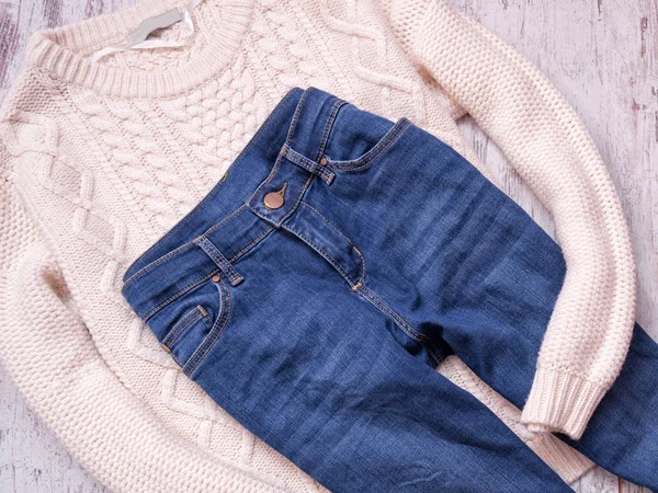 Jersey blanco y jeans sobre fondo de madera. Concepto de moda, vista superior — Foto de Stock