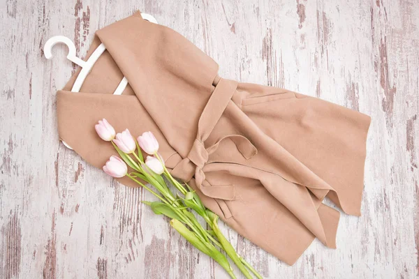 Bir kemer, Pembe Laleler, beyaz trempel ile bej bir palto. Moda kavramı. Yukarıdan görüntülemek