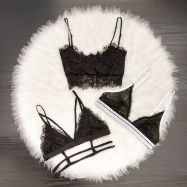 Moda kavramı, üç dantel büstiyer üzerinde beyaz kürk, üstten görünüm