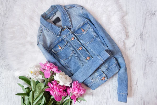 Kot ceket ve peonies bir buket. Moda kavramı, beyaz kürk arka planda