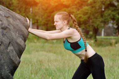 Spor giyim kız lastik yükseltir. Sokak egzersiz.