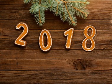 Köknar şubesine çerçeve altında ahşap arka plan üzerinde rakamlar 2018. Metin için yer