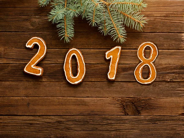 Köknar şubesine çerçeve altında ahşap arka plan üzerinde rakamlar 2018. Metin için yer