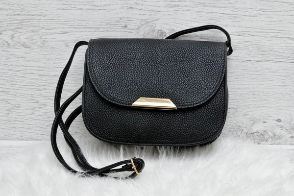 Beyaz kürk, hafif ahşap arka plan üzerinde siyah çanta — Stok fotoğraf