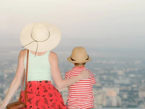 Mamma och son och titta på staden från en höjd. Bakifrån, kväll tid — Stockfoto