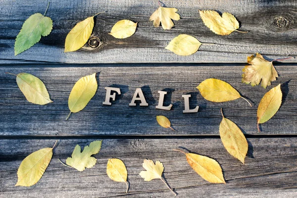 Word op een houten achtergrond, frame van geel Herfstbladeren — Stockfoto