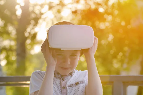 Junge nimmt den Helm der virtuellen Realität im Freien ab — Stockfoto