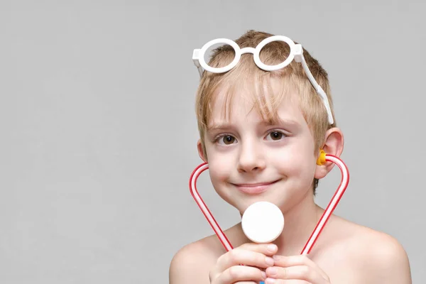 Roztomilý chlapec hraje doktora. Hračky brýle a phonendoscope. Portrét — Stock fotografie