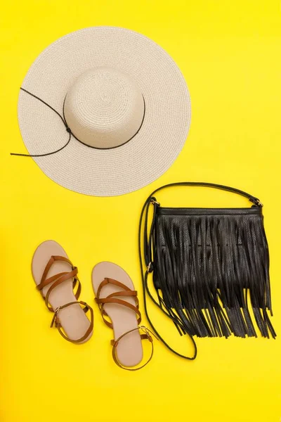 Concetto alla moda. Cappello da spiaggia donna, borsetta, sandali. sfondo giallo — Foto Stock