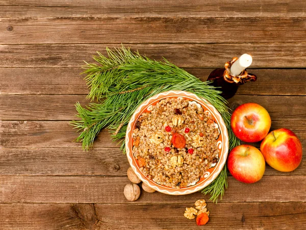 Вид зверху страви традиційної різдвяної страви слов'ян Кутія. Дерев'яний фон ялинових гілок, яблук — стокове фото