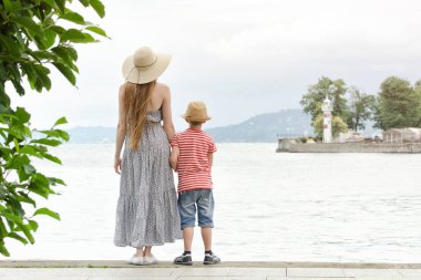 Anne ve oğlu iskele, deniz feneri ve dağlar mesafe tutuyoruz. Arkadan Görünüm