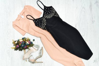 Bej ve siyah elbise, gümüş ayakkabı, bir buket çiçek. Moda kavramı.