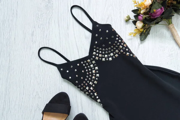 Pequeño vestido negro con remaches, zapatos negros y un ramo de flores. Concepto de moda —  Fotos de Stock