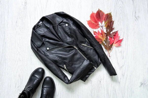 Moda kavramı. Siyah deri ceket, siyah ayakkabı ve kırmızı yaprakları.