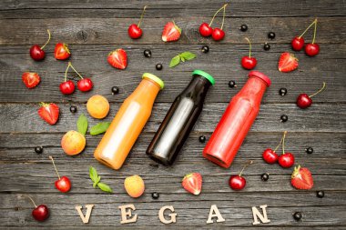 Üç şişe suyu, meyve ve yazıt vegan koyu ahşap zemin, gıda kavramı ile