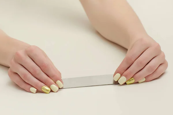 Lima per unghie in mani femminili, posto per testo. Fondo bianco — Foto Stock