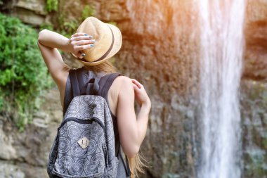 Şapkalı Kız şelale hayran. Arkadan görüntülemek
