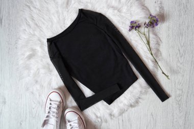 Siyah kazak üzerine beyaz kürk, spor ayakkabı. Moda kavramı